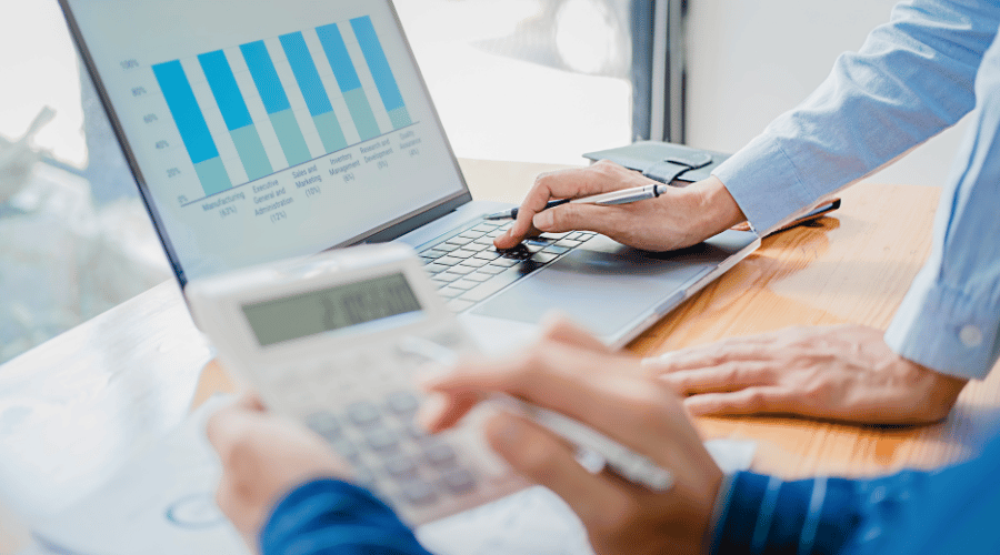 a woman holding laptop and calculating